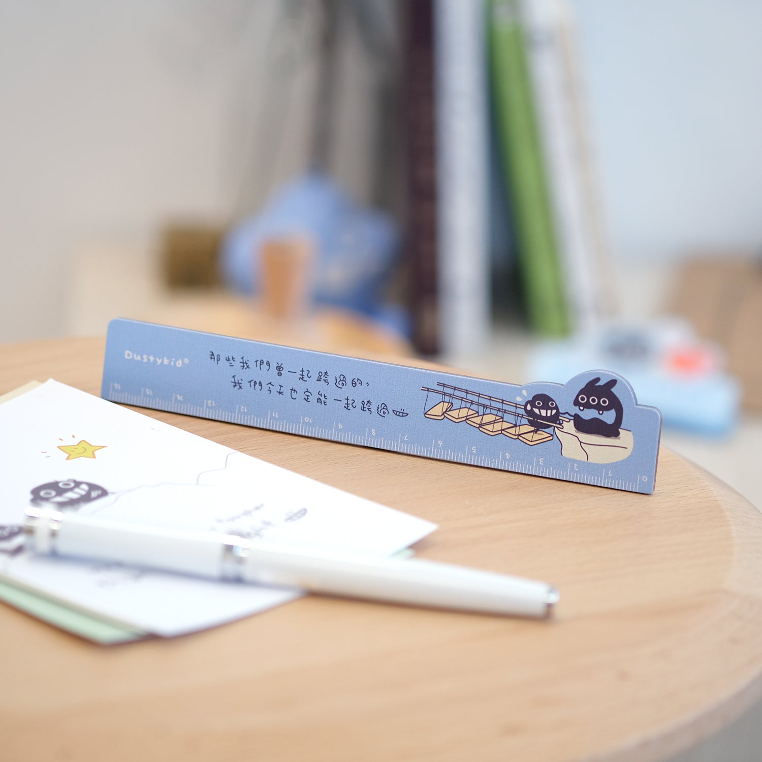 Ruler with cartoon design on a wooden surface with stationery items